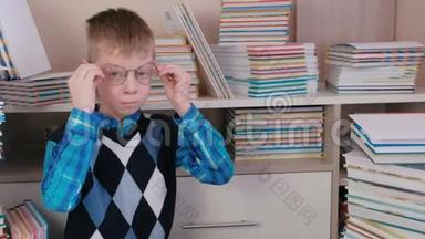 微笑的七岁男孩戴着眼镜坐在地板上的书。